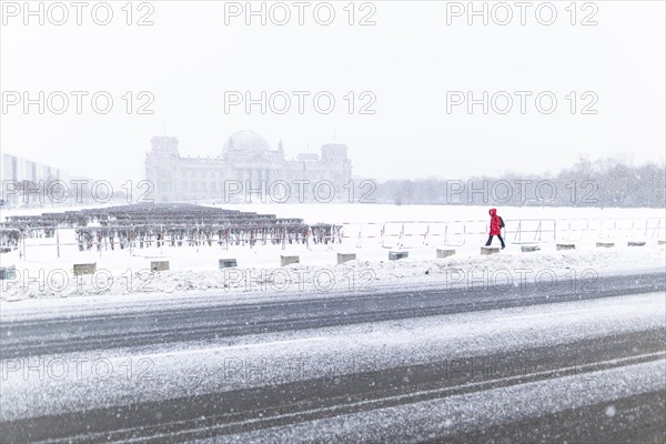 The Reichstag building is silhouetted against snowfall in the government district in Berlin