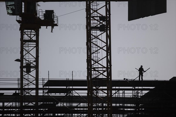 The silhouette of a scaffolder stands out on a construction site in Berlin