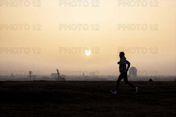 A jogger stands out against the rising sun in Berlin