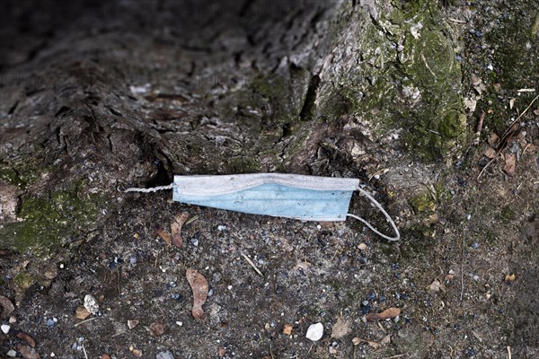 A discarded mouth-nose protection lies on the ground