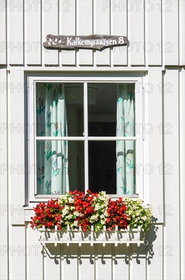 Wooden holiday home with flower box by the window in the picturesque village of Nordkoster