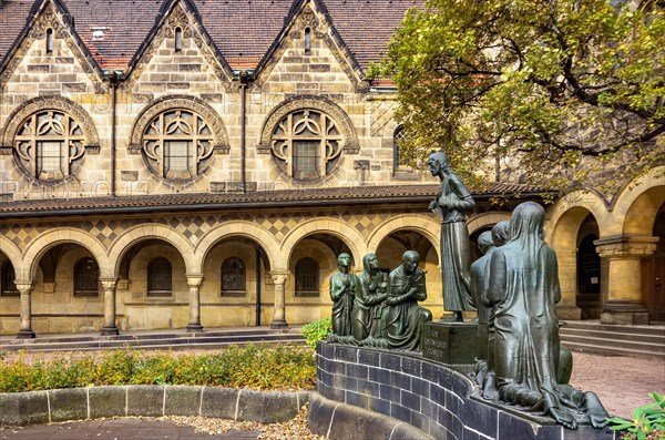 Court of honour with arcades and group sculpture of the Consoling Christ by Selmar Werner. The church