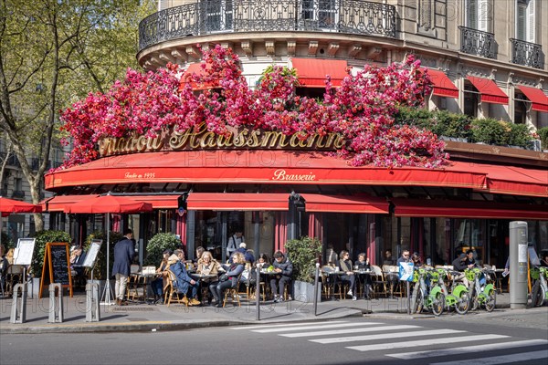 Flower-decorated facade at the Triadou Haussmann sidewalk cafe