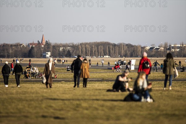 People stand out on Tempelhofer Feld in spring weather in Berlin