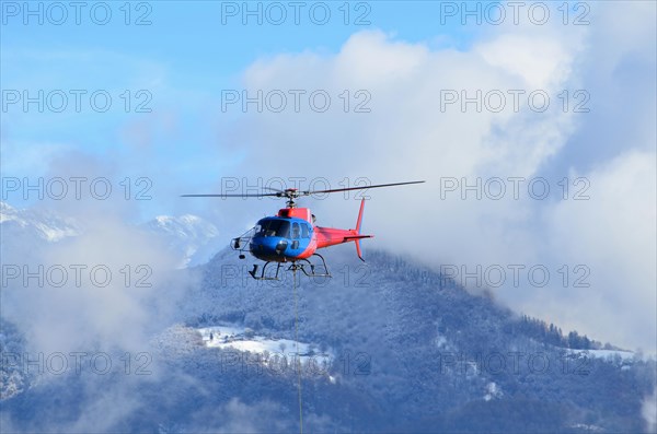 Helicopter Flying over Snow-capped Mountain in Switzerland
