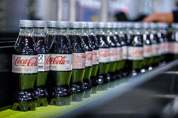 Coca Cola bottles on a conveyor belt of a bottling line