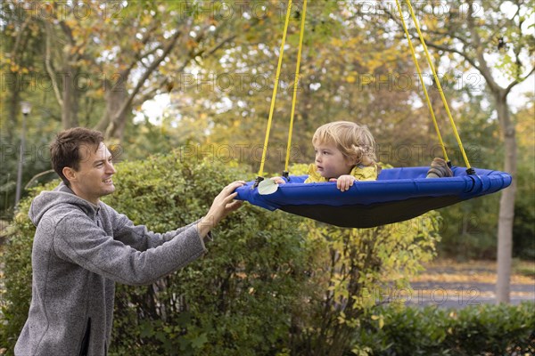 Father and son playing with a swing