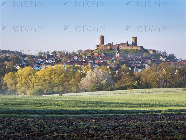 View over fields to the castle and town of Muenzenberg in the Wetterau in spring morning light