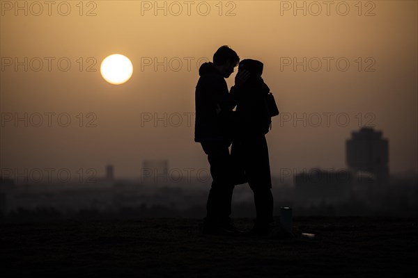 Two people silhouetted against the rising sun in Berlin