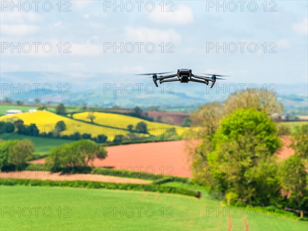 Drone in flight over fields and farms