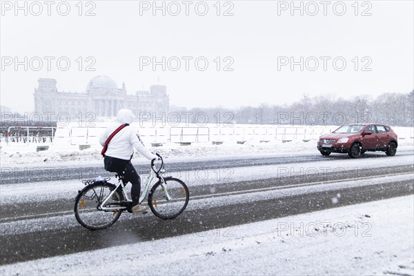 The Reichstag building is silhouetted against snowfall in the government district in Berlin