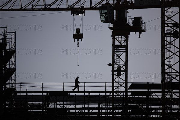 The silhouette of a scaffolder stands out on a construction site in Berlin