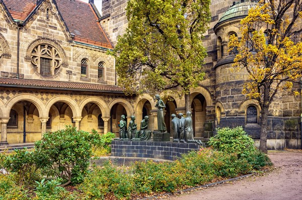 Court of honour with arcades and group sculpture of the Consoling Christ by Selmar Werner. The church