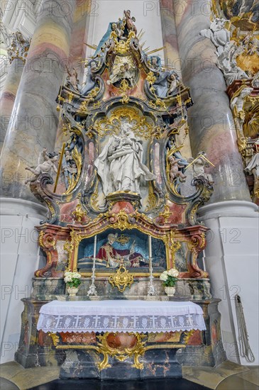 Side altar with floral decoration and saint's relic St. Benedict