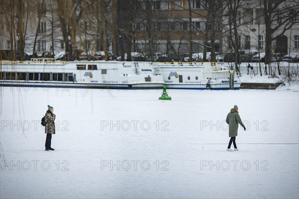 People walk on the frozen Landwehrkanal in Berlin. 11.02.2021.