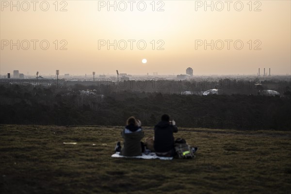 Two people silhouetted against the rising sun in Berlin