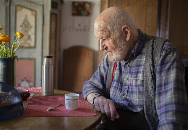 Subject: Old man sitting alone at the table.