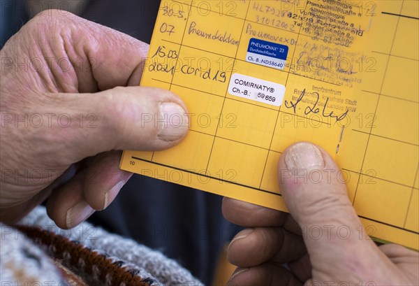 An 81-year-old man holds his vaccination certificate with the entry of a Corona vaccination. Remscheid