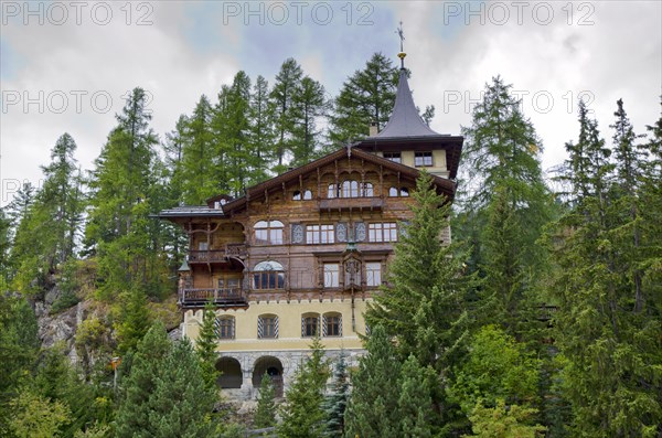 Old Elegant House with Green Trees on a Hill in St Moritz