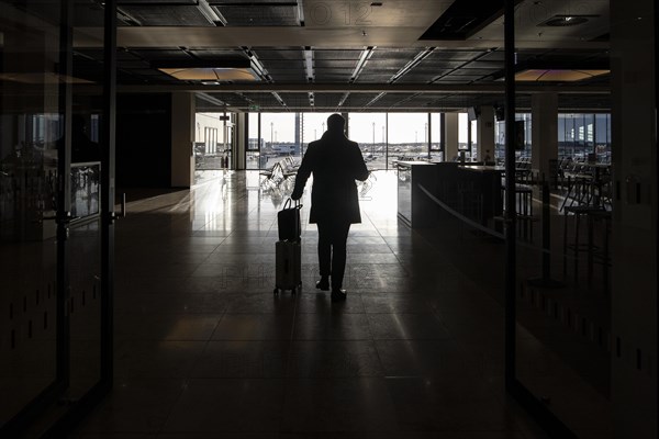 A traveller with luggage at BER Berlin-Brandenburg Airport in Berlin