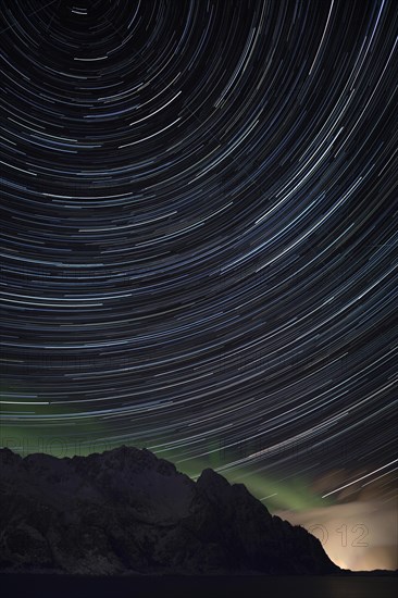 Star trails with some northern lights and rain clouds near Henningsvaer