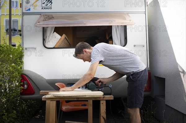 Man tinkering with his caravan.