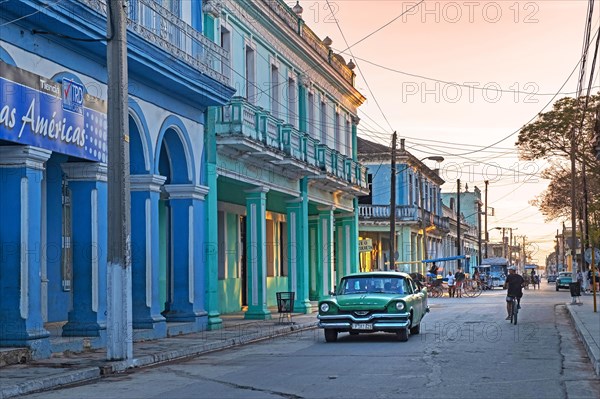 Classic American 1950s Dodge Mayfair car driving through street at sunset in the city Colon