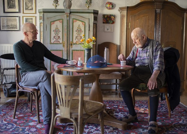 Subject: Father and son sitting together at the table