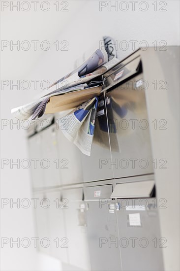 Newspapers and letters stuck in the opening of a crowded letterbox. Berlin