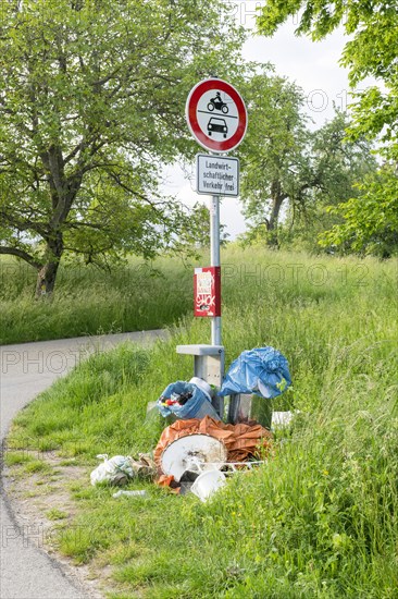 Destroyed rubbish bin with illegally deposited rubbish