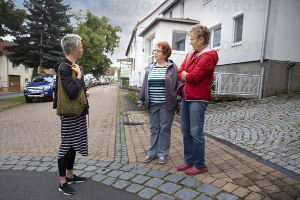 Neighbourhood. Women on the street are talking to each other.