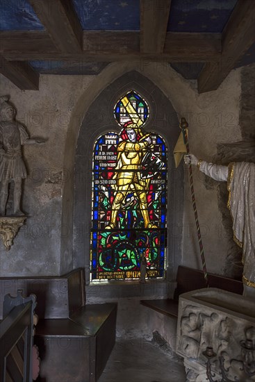 Colourful stained glass window from 1914 with St. George with the dragon in the castle chapel of Thurant Castle