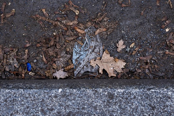 A discarded mouth-nose protection lies on the ground