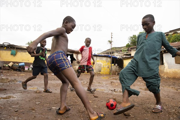 Children play football in Bomeh Village at the KissyRoad dumpsite