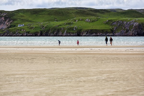 Walkers on the sandy beach
