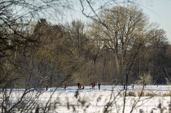 People walk across the ice and skate on the frozen Hermsdorfer See lake in Berlin Reinickendorf. Berlin