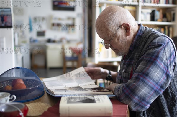 Subject: Old man looking into a photo album