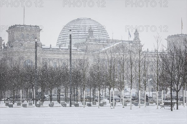 The Reichstag building is silhouetted against snowfall in the government district in Berlin