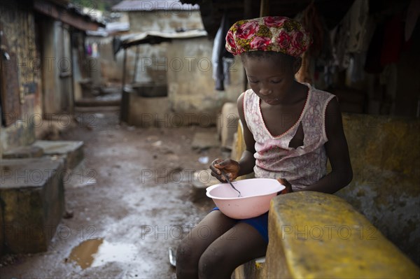 Girl with a plate living in Bomeh Village at the KissyRoad dumpsite