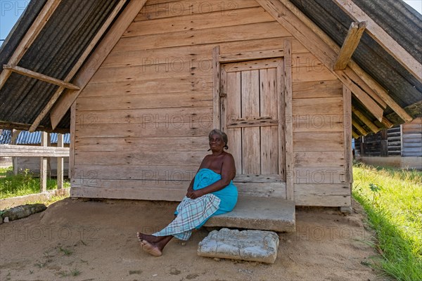 Afro-Surinamese woman posing in front of wooden house in the village Aurora