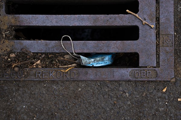 A discarded mouth-nose protection lies on the ground