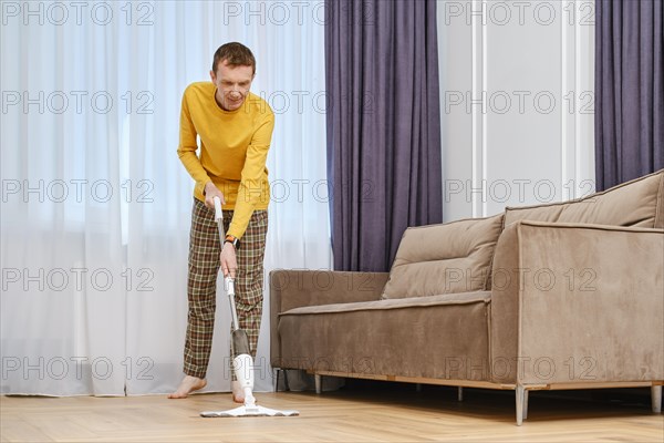 Middle age man mopping floors in living room