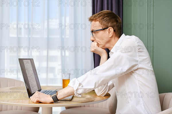 Middle aged man submitting individual income tax return form from home
