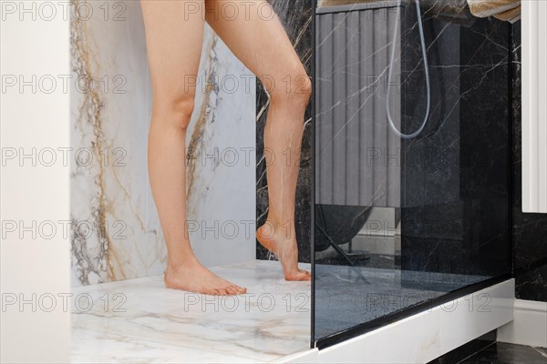 Unrecognizable woman washing her feet in shower cabin