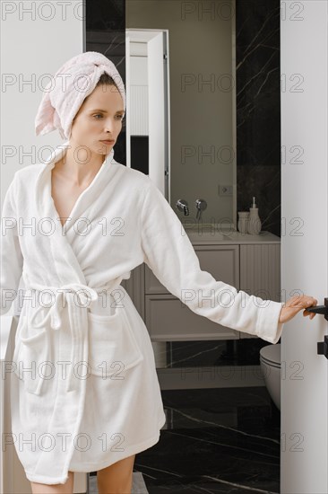 Young woman coming out of bathroom after shower in the morning