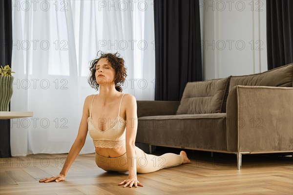 Woman doing yoga at home in cobra position