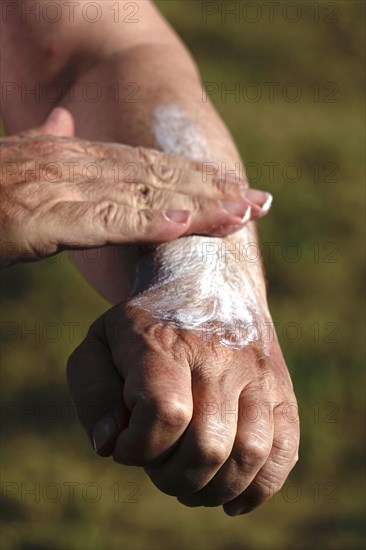 Man puts on sunscreen