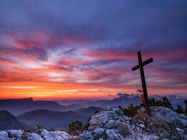 Iceberg summit cross and red clouds at dawn