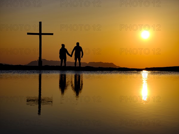Couple next to summit cross at sunset