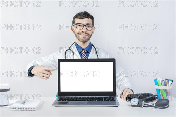 Smiling doctor pointing at an advertisement on the laptop screen